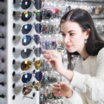Yuong attractive brunette girl trying on sunglasses.