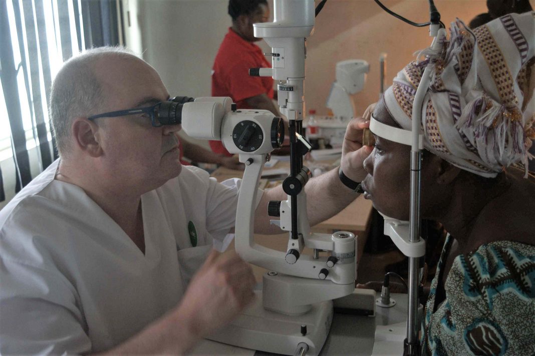 El óptico optometrista Pedro Duc realizando un examen a un paciente en Ghana