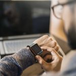 Young freelancer checking time while working.